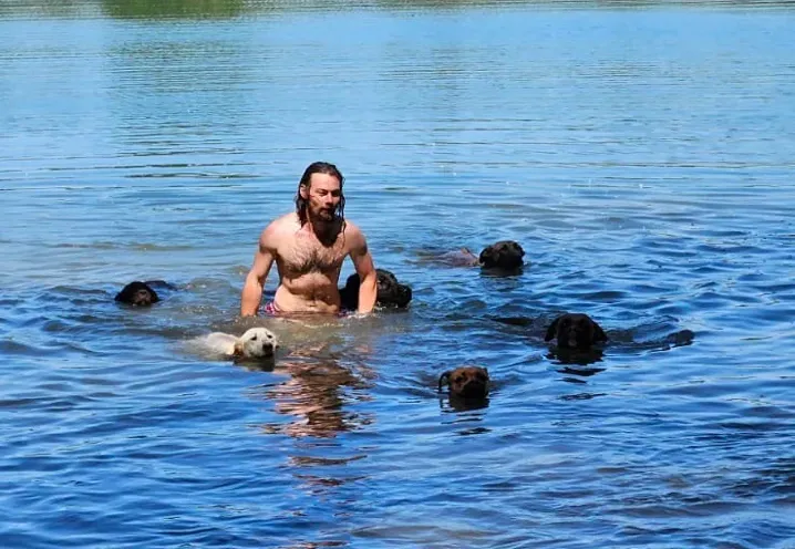 Lucas Becker badet mit seinen Hunden im See